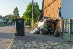 A pile of old furniture and residential junk on a curb awaiting a haul-away and debris removal service.